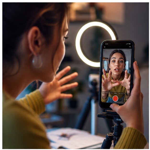 Creator che prepara hook visivi AI per TikTok e Instagram su smartphone e laptop